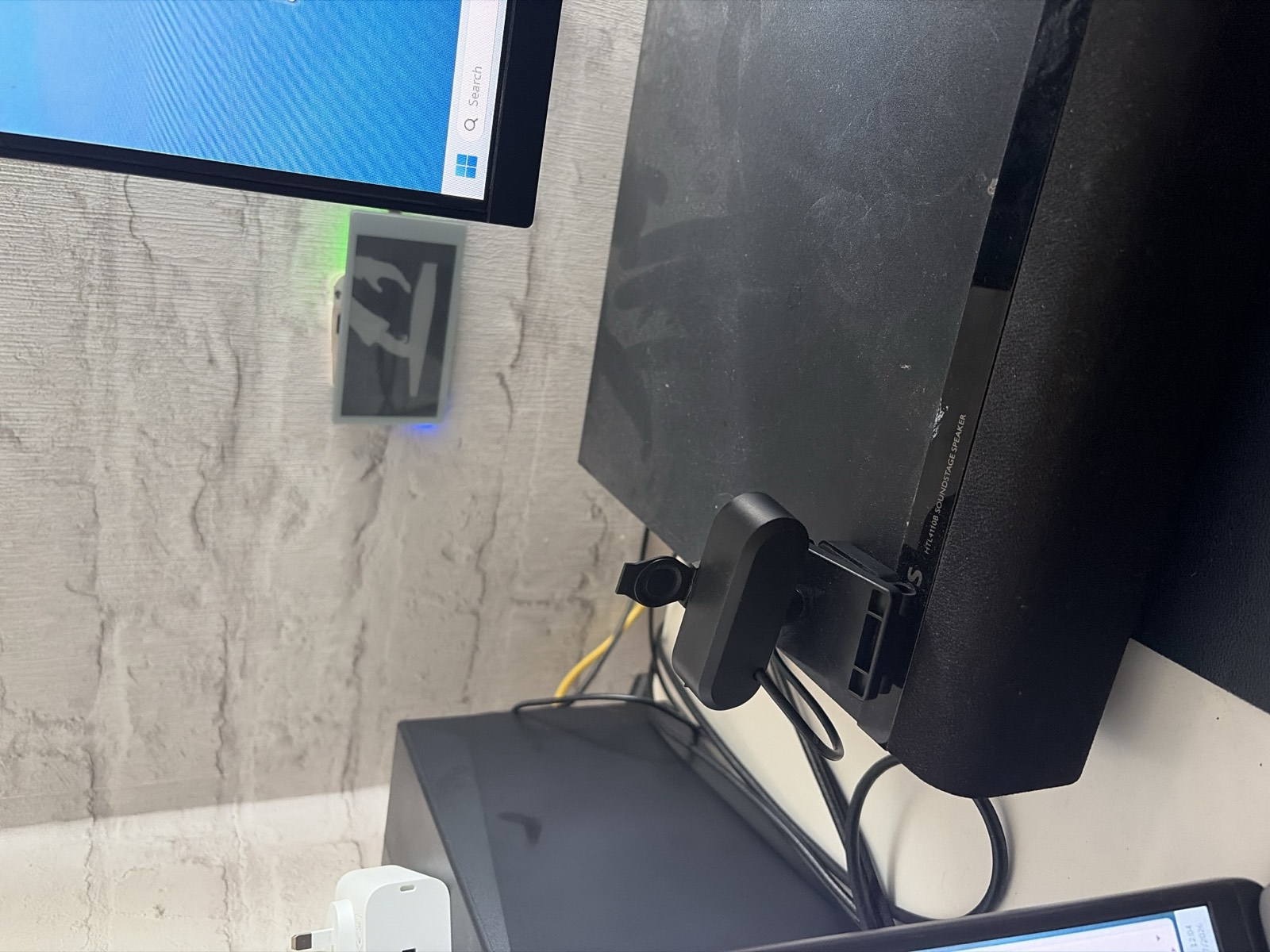 The test rig on the desk: the e-paper panel on the wall playing Bad Apple, beside a monitor and soundbar